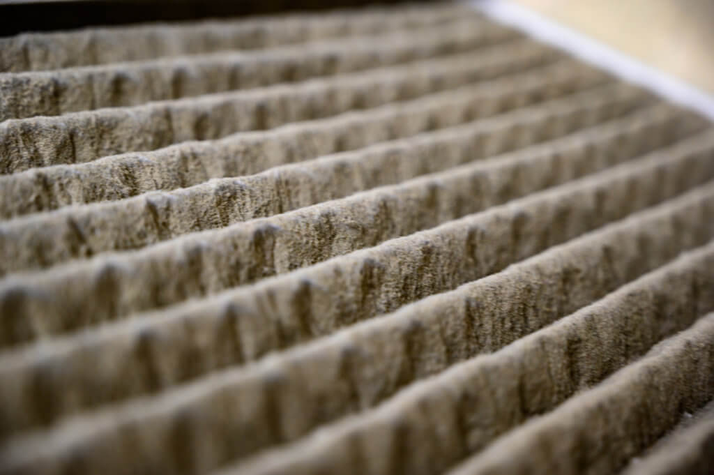 Dirty and dusty used house air filter close-up Dirty Clogged Air Filter