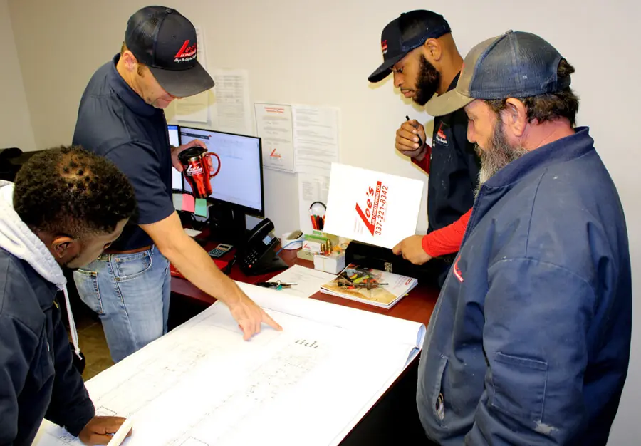 Lee’s Air Conditioning technicians discussing AC repair.