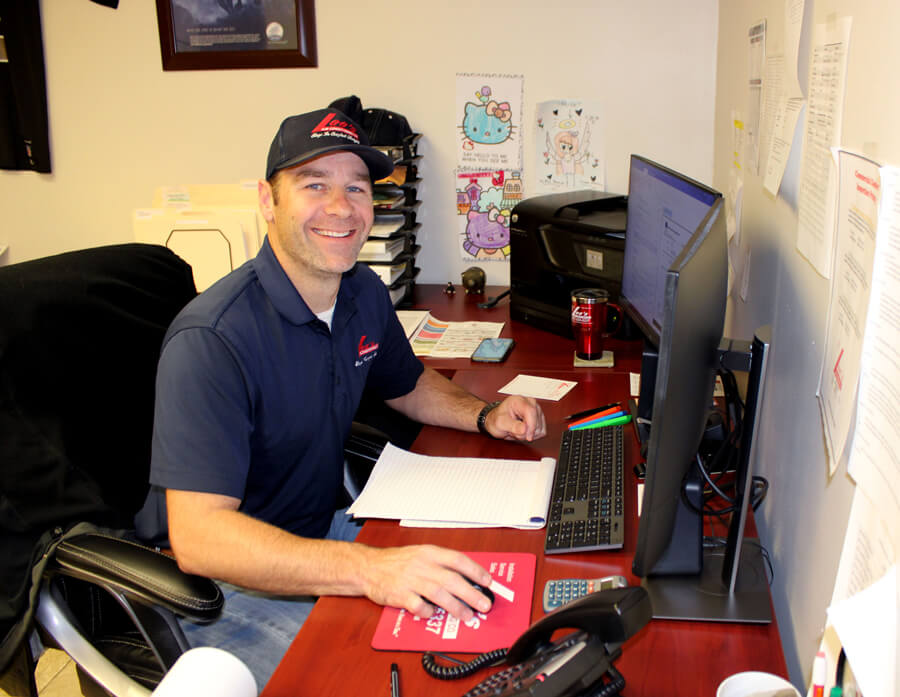 Lee's Tech at Desk Smiling
