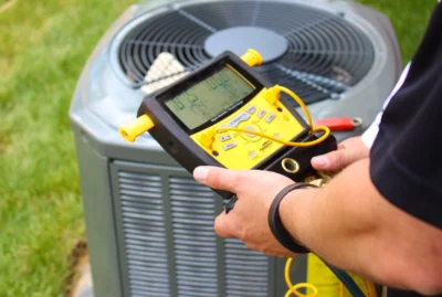 HVAC service technician testing an AC unit.