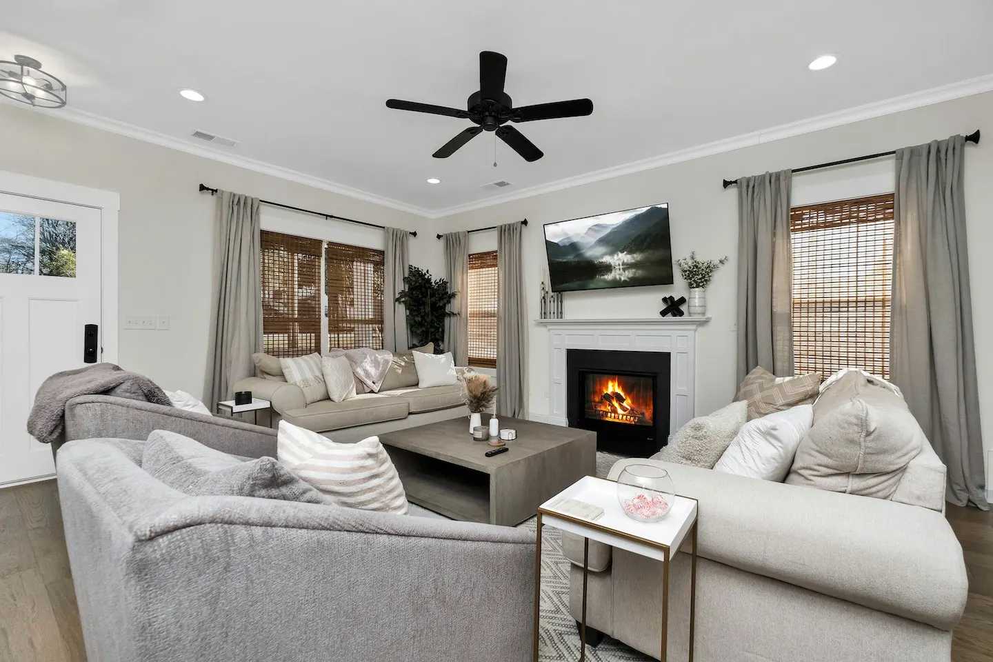A living room in Lafayette, Louisiana with a black ceiling fan and a fireplace.
