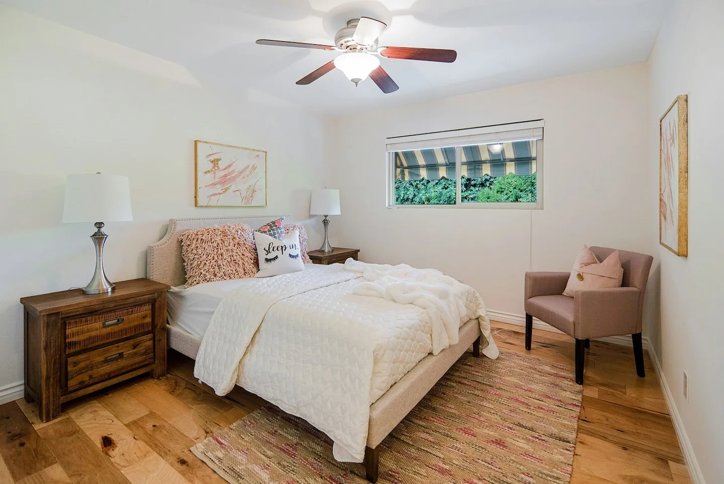 A bedroom in Lafayette, Louisiana with a dark wood ceiling fan in the summertime.