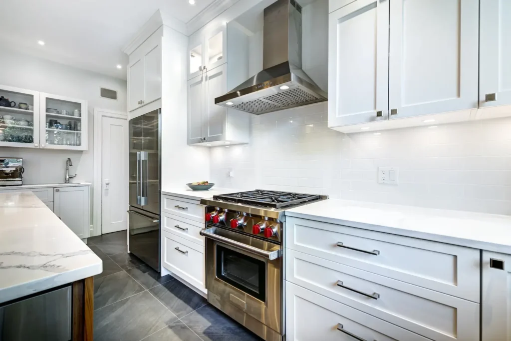 White kitchen with stainless steel kitchen ventilation and range.