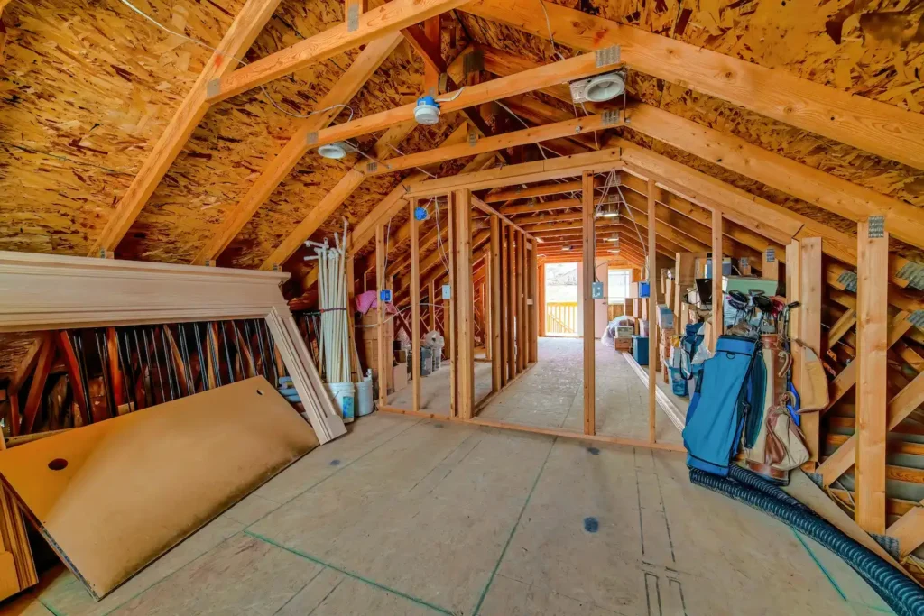 Interior of a pitched roof attic being used for storage.