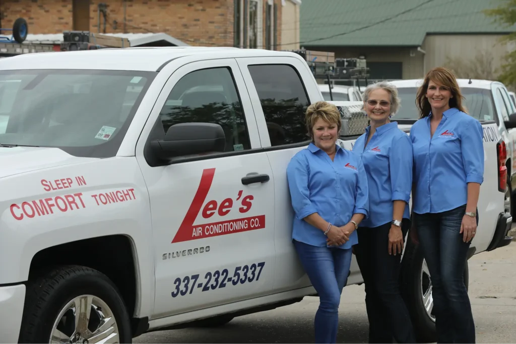 Three Lee’s AC employees standing next to one another, leaning against a service truck.