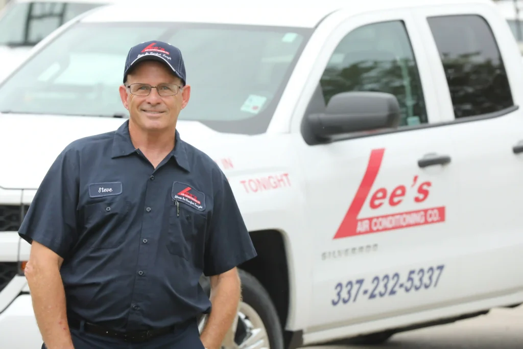 Lee’s AC in Lafayette HVAC technician standing in front of vehicle and smiling.